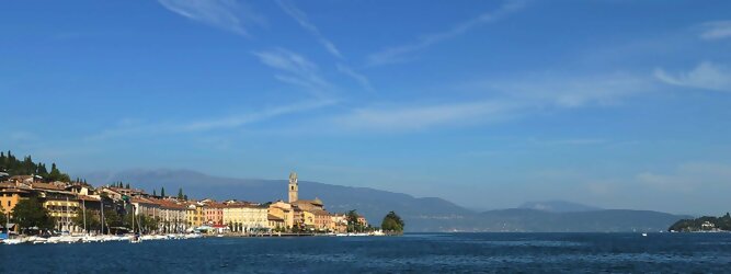 Trip Azoren beliebte Urlaubsziele am Gardasee -  Mit einer Fläche von 370 km² ist der Gardasee der größte See Italiens. Es liegt am Fuße der Alpen und erstreckt sich über drei Staaten: Lombardei, Venetien und Trentino. Die maximale Tiefe des Sees beträgt 346 m, er hat eine längliche Form und sein nördliches Ende ist sehr schmal. Dort ist der See von den Bergen der Gruppo di Baldo umgeben. Du trittst aus deinem gemütlichen Hotelzimmer und es begrüßt dich die warme italienische Sonne. Du blickst auf den atemberaubenden Gardasee, der in zahlreichen Blautönen schimmert - von tiefem Dunkelblau bis zu funkelndem Türkis. Majestätische Berge umgeben dich, während die Brise sanft deine Haut streichelt und der Duft von blühenden Zitronenbäumen deine Nase kitzelt. Du schlenderst die malerischen, engen Gassen entlang, vorbei an farbenfrohen, blumengeschmückten Häusern. Vereinzelt unterbricht das fröhliche Lachen der Einheimischen die friedvolle Stille. Du fühlst dich wie in einem Traum, der nicht enden will. Jeder Schritt führt dich zu neuen Entdeckungen und Abenteuern. Du probierst die köstliche italienische Küche mit ihren frischen Zutaten und verführerischen Aromen. Die Sonne geht langsam unter und taucht den Himmel in ein leuchtendes Orange-rot - ein spektakulärer Anblick.